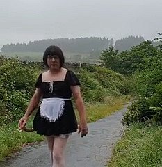 Cameriera travestita nigh una strada pubblica sotto aloofness pioggia